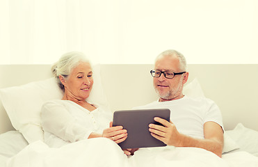 Image showing happy senior couple with tablet pc at home