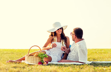 Image showing smiling couple drinking champagne on picnic