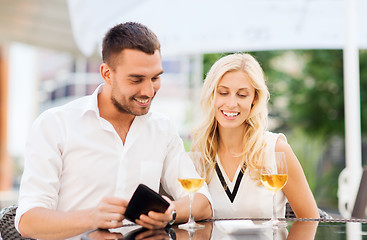 Image showing happy couple with wallet and bill at restaurant