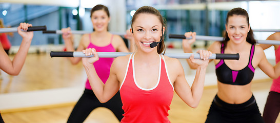 Image showing group of smiling people working out with barbells