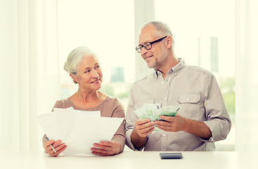 Image showing senior couple with money and calculator at home