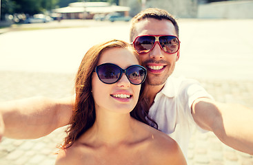Image showing smiling couple wearing sunglasses making selfie
