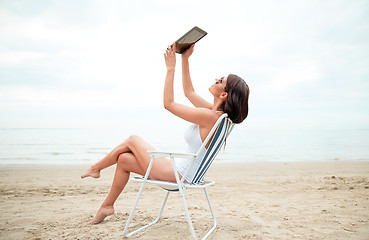 Image showing happy woman with tablet pc taking selfie on beach