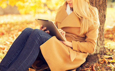 Image showing young woman with tablet pc in autumn park