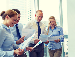Image showing smiling businesspeople with papers in office