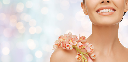 Image showing close up of smiling woman with orchid flower