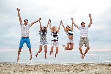 Image showing smiling friends in sunglasses walking on beach