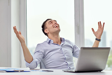Image showing happy businessman with laptop in office