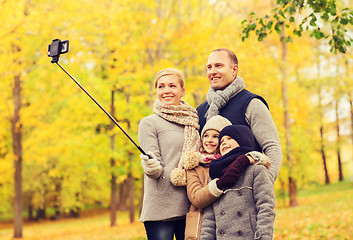 Image showing happy family with smartphone and monopod in park