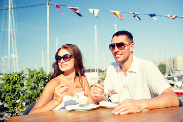 Image showing smiling couple eating dessert at cafe