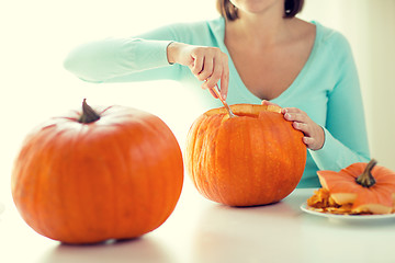 Image showing close up of woman with pumpkins at home