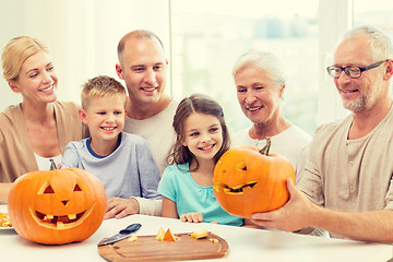 Image showing happy family sitting with pumpkins at home