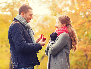 Image showing smiling couple with engagement ring in gift box