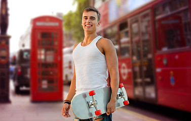 Image showing smiling man with skateboard on london city street