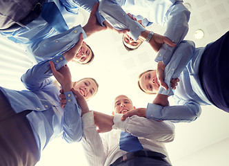 Image showing smiling group of businesspeople standing in circle