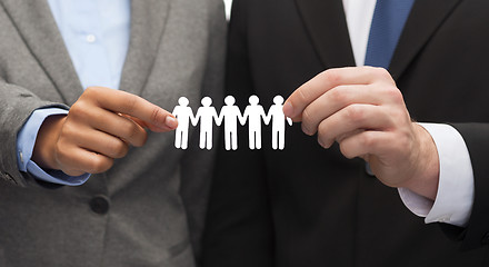 Image showing businessman and businesswoman holding paper team