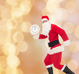 Image showing man in costume of santa claus with clock