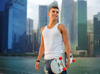 Image showing smiling man with skateboard over singapore city