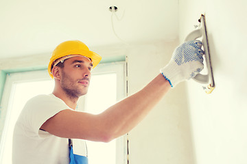 Image showing builder working with grinding tool indoors