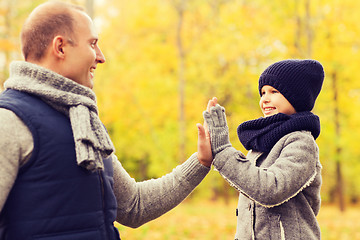Image showing happy father and son making high five in park