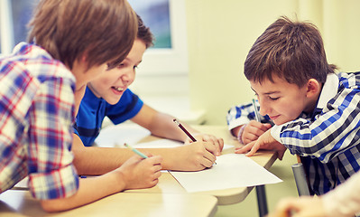 Image showing group of schoolboys writing or drawing at school