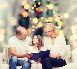 Image showing happy family with book at home