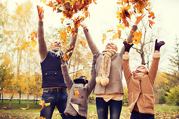 Image showing happy family playing with autumn leaves in park