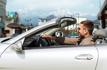 Image showing happy man driving cabriolet car over city in japan