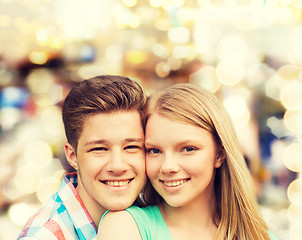 Image showing smiling couple hugging over lights background