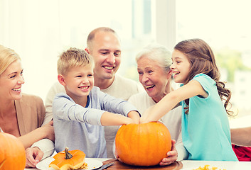 Image showing happy family sitting with pumpkins at home