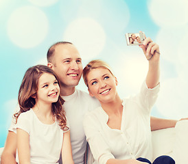 Image showing happy family with camera at home