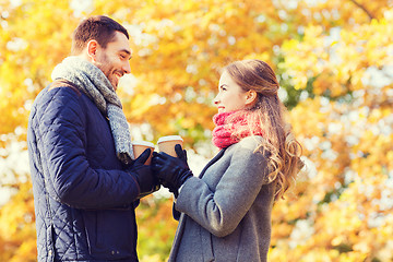 Image showing smiling couple with coffee cups in autumn park