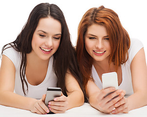 Image showing two smiling teenagers with smartphones