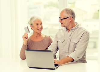 Image showing happy senior couple with laptop and credit card