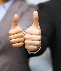 Image showing businessman and businesswoman showing thumbs up