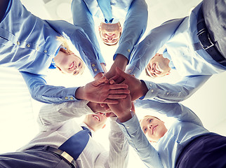 Image showing smiling group of businesspeople standing in circle