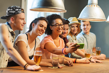 Image showing happy friends with smartphone taking selfie at bar