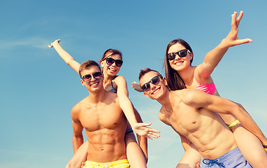 Image showing smiling friends having fun on summer beach