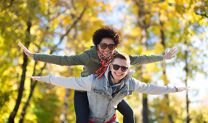 Image showing happy teenage couple in shades having fun outdoors