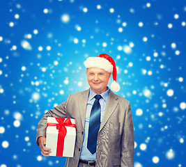 Image showing smiling man in suit and santa helper hat with gift