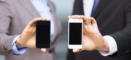 Image showing businessman and businesswoman with smartphones