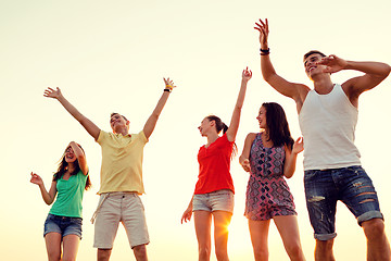 Image showing smiling friends dancing on summer beach