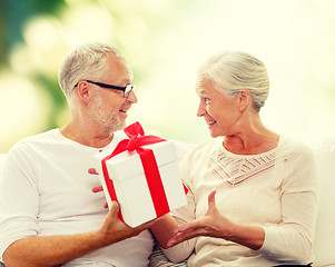 Image showing happy senior couple with gift box at home