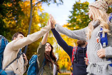 Image showing group of smiling friends with backpacks hiking