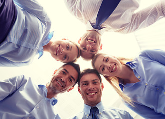 Image showing smiling group of businesspeople standing in circle