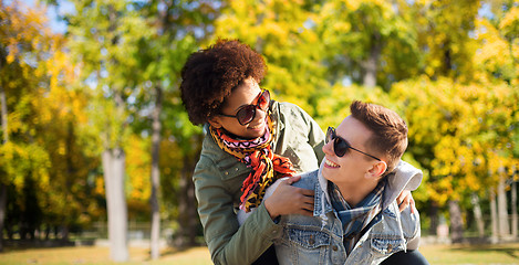 Image showing happy teenage couple in shades having fun outdoors