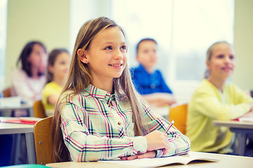 Image showing group of school kids with notebooks in classroom