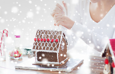 Image showing close up of woman making gingerbread house at home