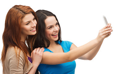 Image showing two smiling teenagers with smartphone