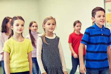 Image showing group of smiling school kids walking in corridor